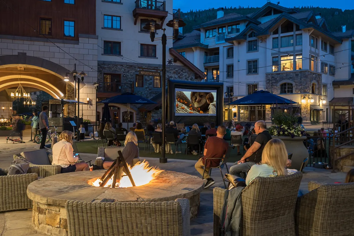 Featuring a cozy fire pit, outdoor movie screen, and comfortable seating, this exterior scene evokes the communal spirit of festival gatherings and local events. The inviting setup suggests memorable evenings with friends, sharing stories, and enjoying entertainment outdoors.